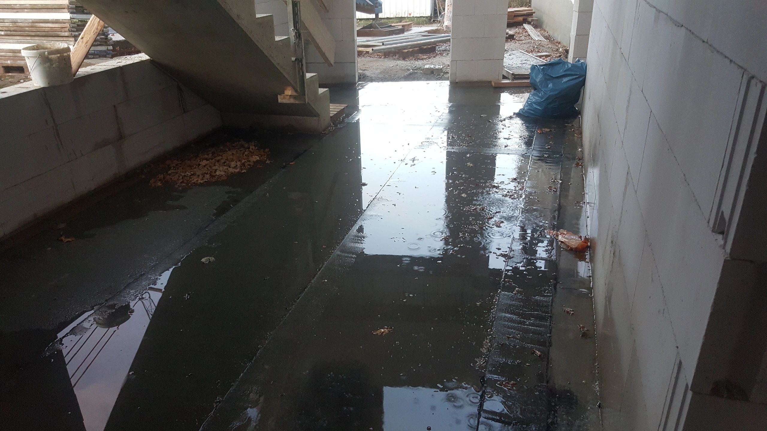 Water intrusion visible in a basement construction area